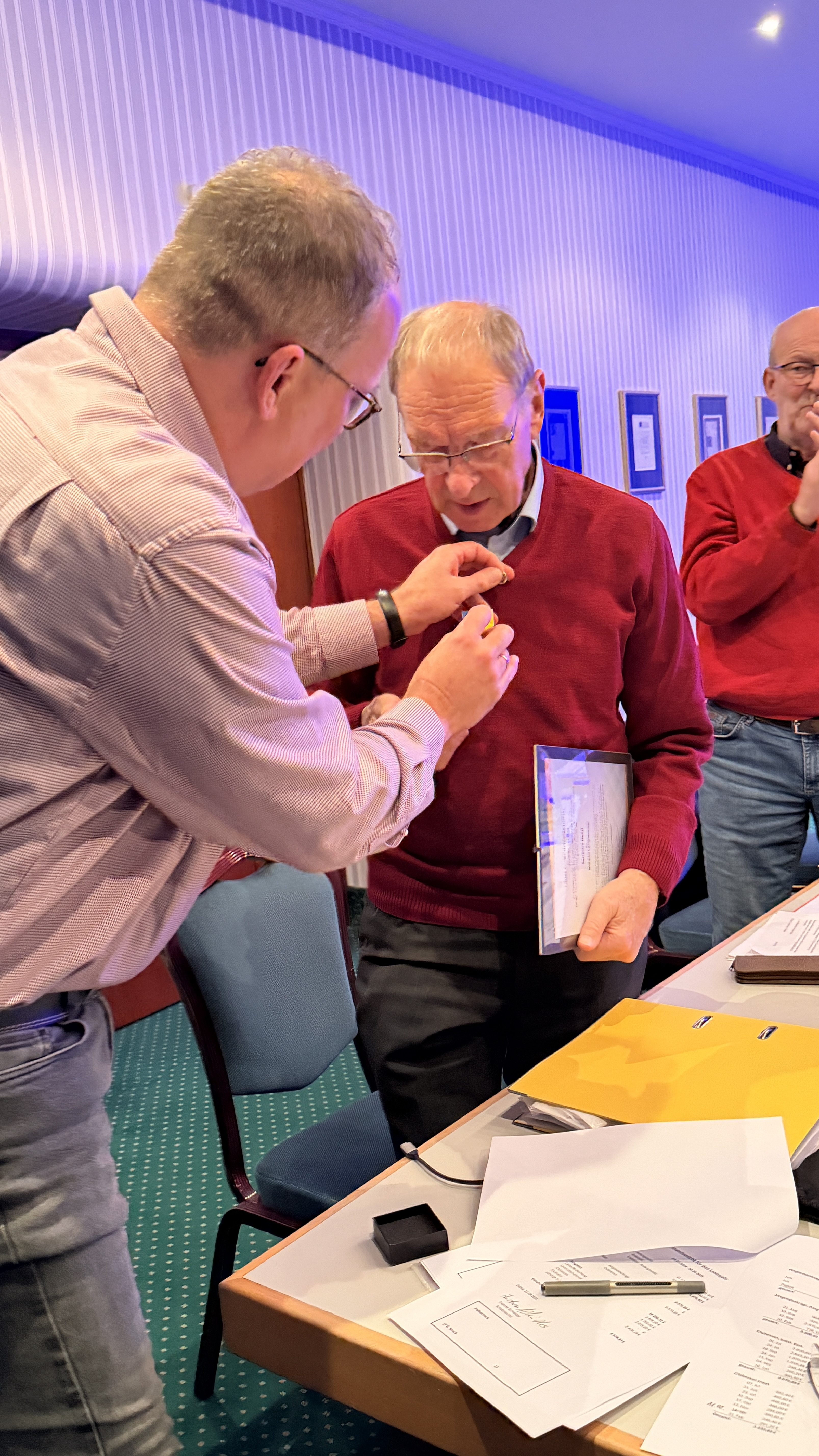 und steckt ihm die Medaille an